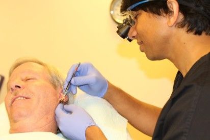Dr. Prasad doing Ear tissue regeneration procedure on a male patient